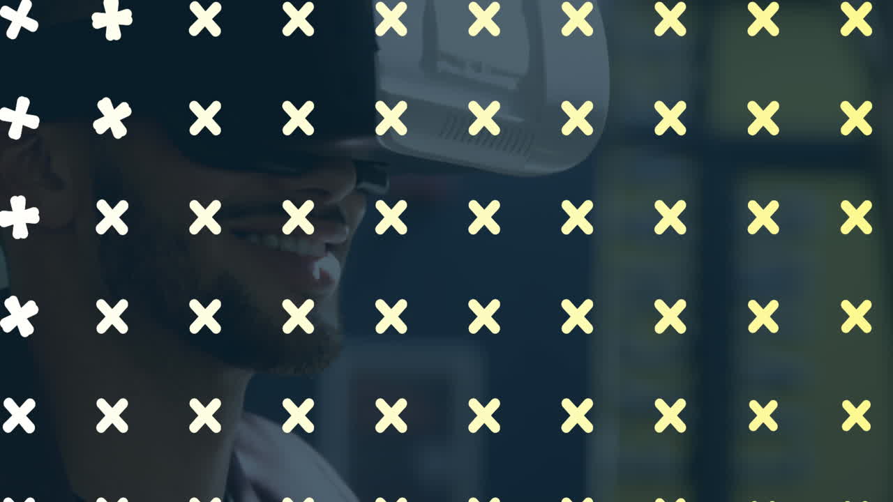 animación de símbolos cruzados diseño de patrón en primer plano de hombre biracial usando auriculares vr en la oficina.