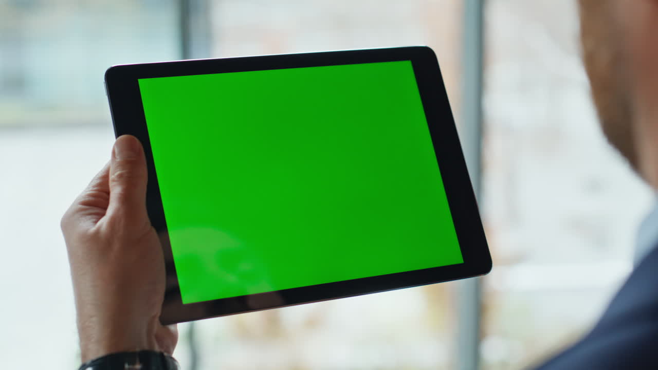 Employee swiping greenscreen tablet at company workplace closeup. Unknown man