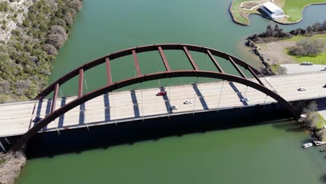 aerial austin pennybacker bridge - panning left to get bridge square then moving slowly right as light traffic crosses. bridge and river filling the frame with no sky included