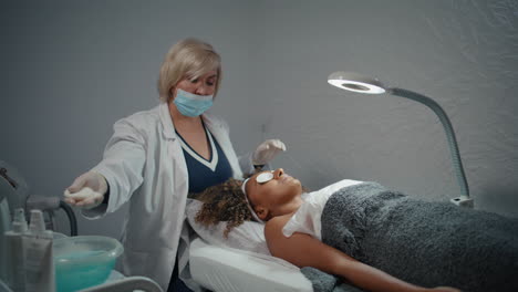 esteticista limpiando la piel de la mujer con almohadillas de algodón. tratamiento facial en la clínica.