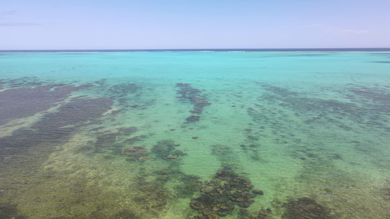 Drone aerial panning over a bright blue ocean in New Caledonia
