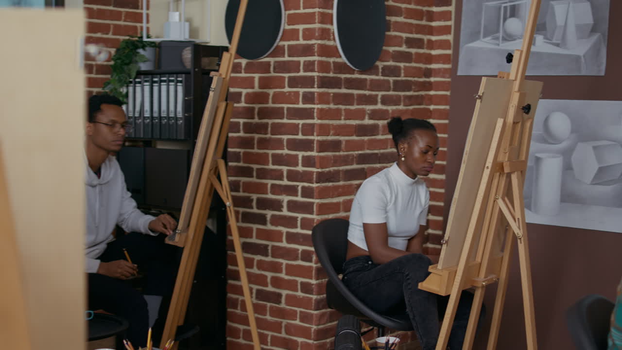 Elder artist pointing at vase model to teach drawing technique