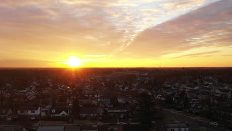 An-aerial-view-over-a-Long-Island-neighborhood-during-a-golden-sunrise-with-clouds-and-blue-skies