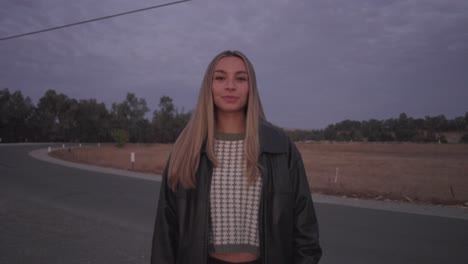 smiling young woman in leather jacket at sunset