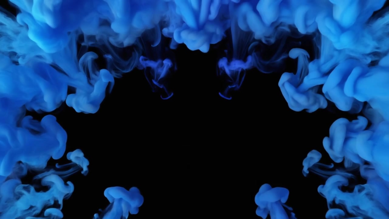 Goccioline d'inchiostro blu che si dissolvono nell'acqua su sfondo nero