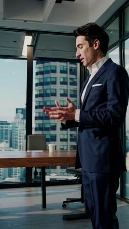 a business professional in a suit gestures while speaking in a modern office