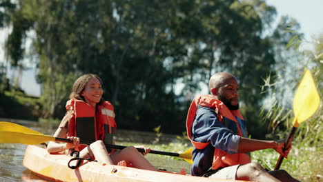 Couple,-high-five-and-rowing-in-kayak-in-lake