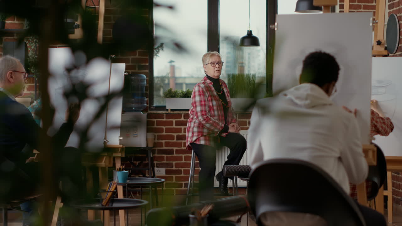 Senior teacher giving art lessons to diverse group of students