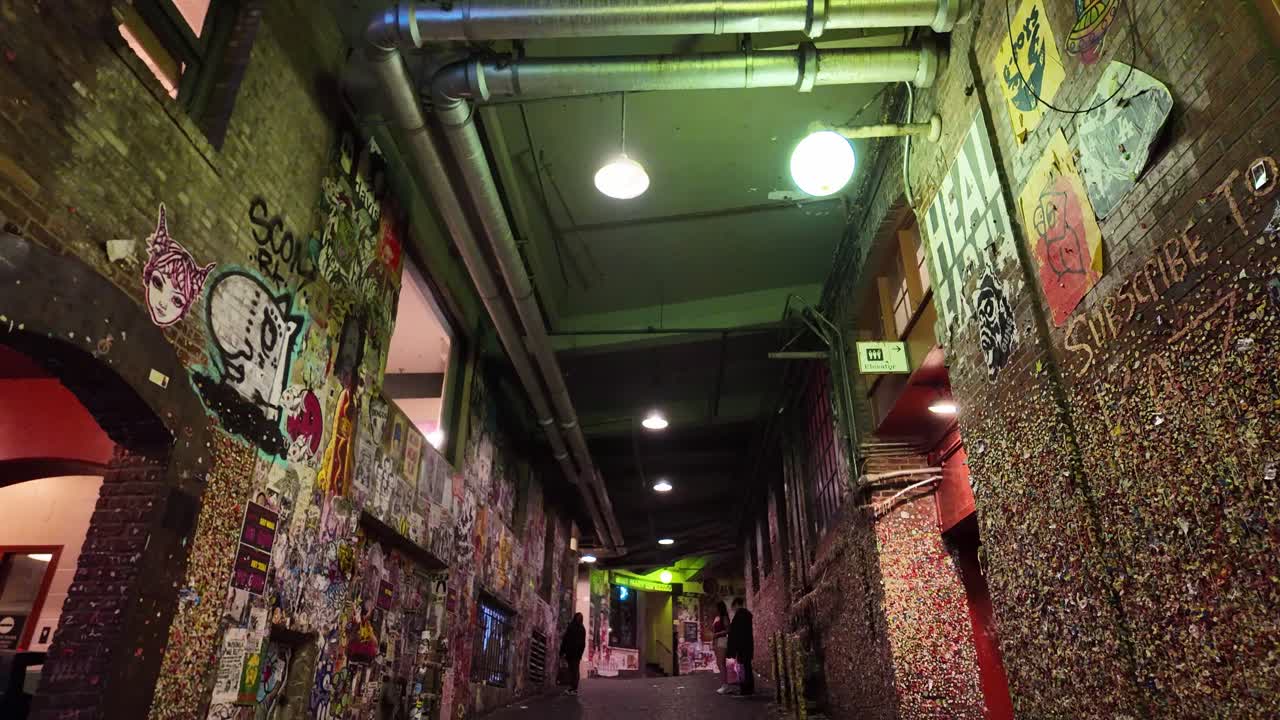 Seattle, Washington'daki Post Alley'de bulunan ünlü Sakız Duvarı'nın gece çekilmiş, gimbal ile yapılan geniş açılı, aşağı doğru hareketli 4K çekimi.