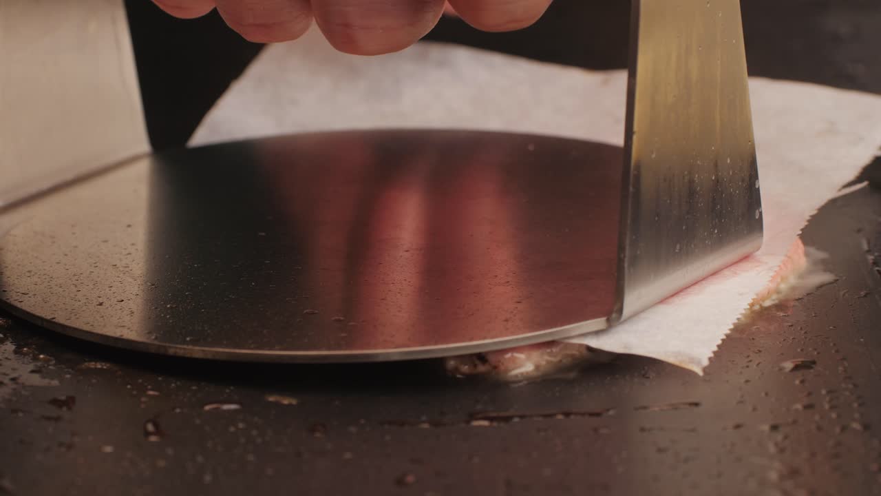 Cooking American fat smash burger on grill close-up. Beef or pork cutlet smashing by burger press. The chef in kitchen of the restaurant making cutlets for burgers - smash burger beefsteak. Fast and street food concept. High quality 4k footage