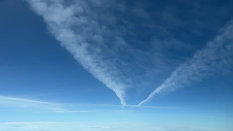 Aerial-view-from-a-jet-cabin-of-two-wake-trails-vanishing