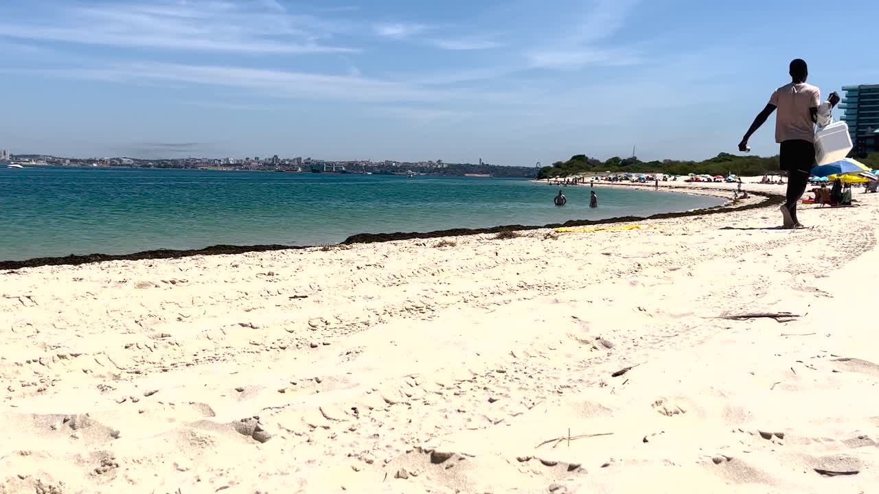 человек, раздающий португальские пончики на пляже в португальском регионе алентежо