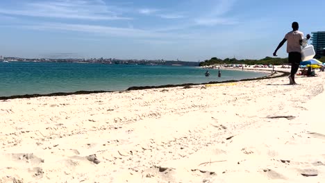 man distributing portuguese doughnuts on beach in the alentejo region of portugal