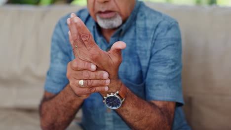 dolor en la mano, hombre mayor y en el sofá con artritis