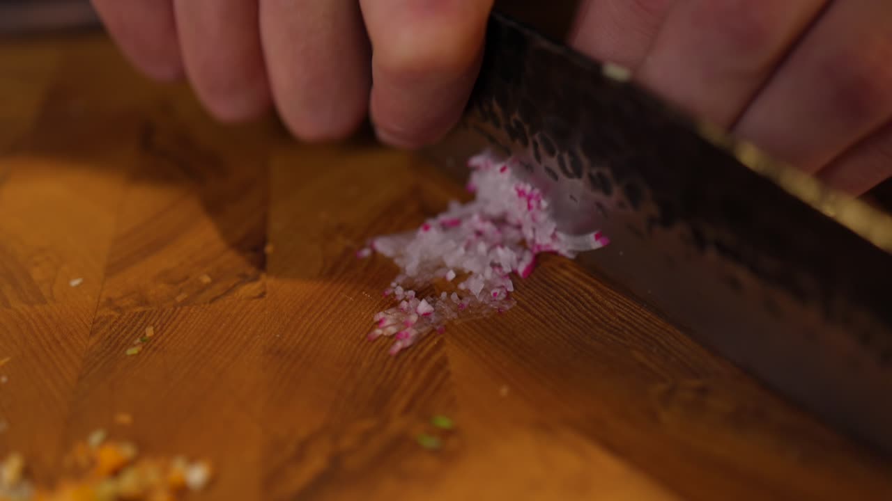 Close Up Of Chef Using Knife To Thinly Slice Radish On Chopping Board