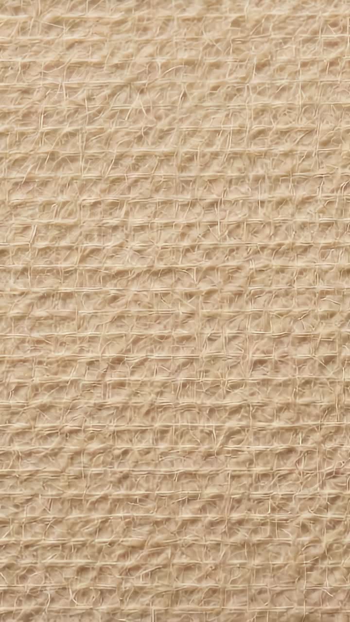 Vertical video: Zooming camera tightening and rising in studio, revealing beige jute fabric detail
