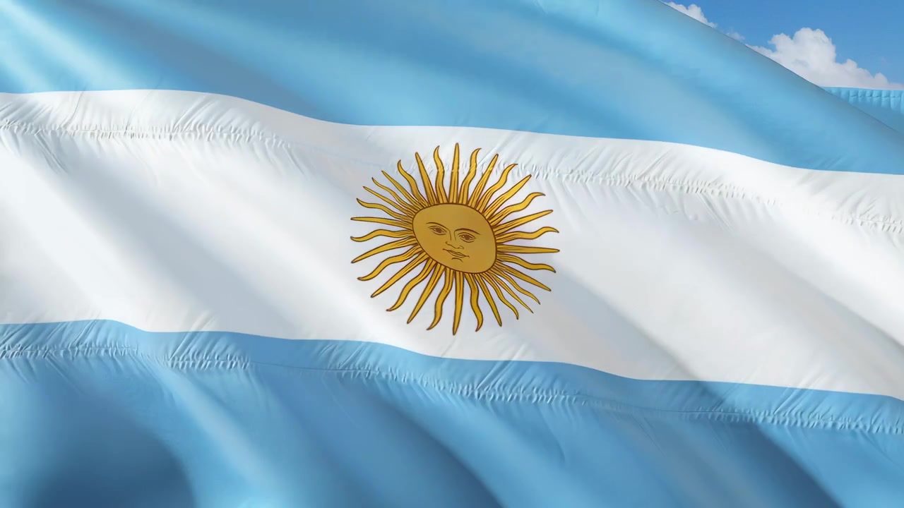 Et flagrende argentinsk flag blafrer på himlen, hvor en let brise får sol-emblemet og syningerne til at bøje sig.