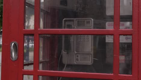 Red-phone-box-in-British-city-medium-panning-shot