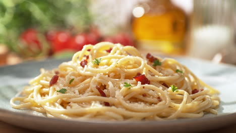 spaghetti carbonara served with pancetta on a plate - presentation of the main course in a sunny italian restaurant, packshot, dolly out