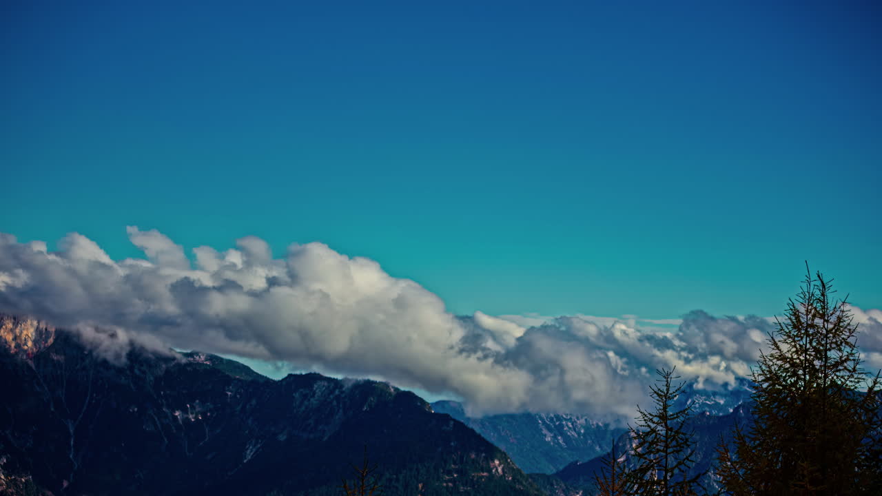 강한  구름은 하늘에서 바위 산꼭대기를 가로질러 날아갑니다.