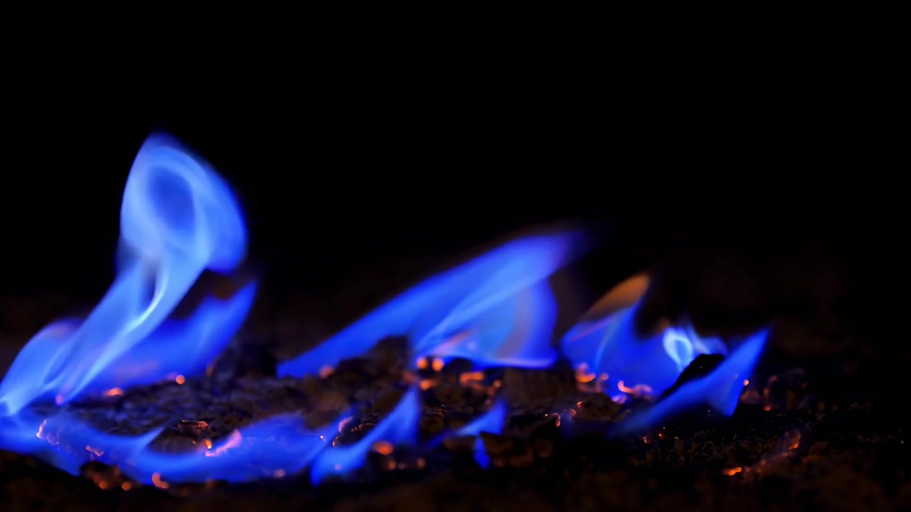 Fiamme blu vivaci che bruciano su sfondo scuro