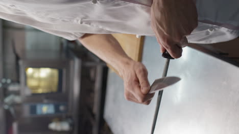 unrecognizable chef sharpening knife