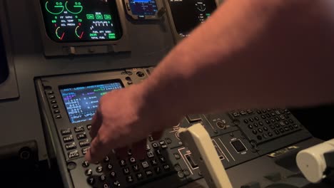 Jet-cockpit-flight-preparation-view-at-night,-Captain-operates-the-FMS-computer