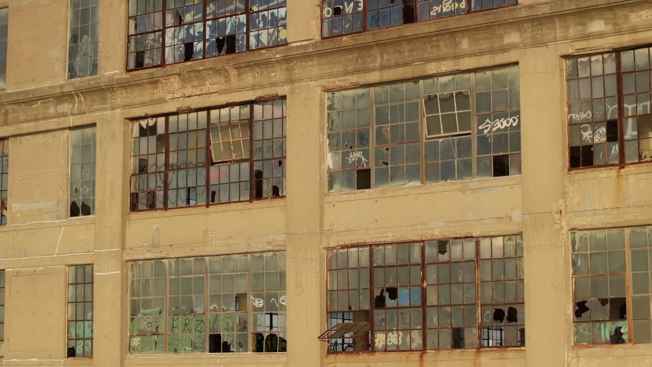 Aerial view of the exterior of an abandoned warehouse at sunset.