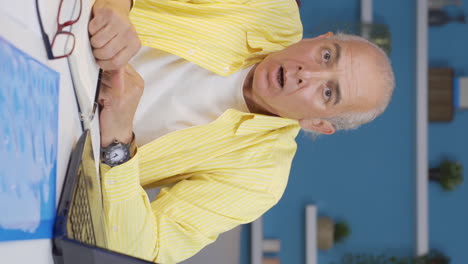 Vertical-video-of-Home-office-worker-old-man-looking-at-camera-with-fear-and-doubt.