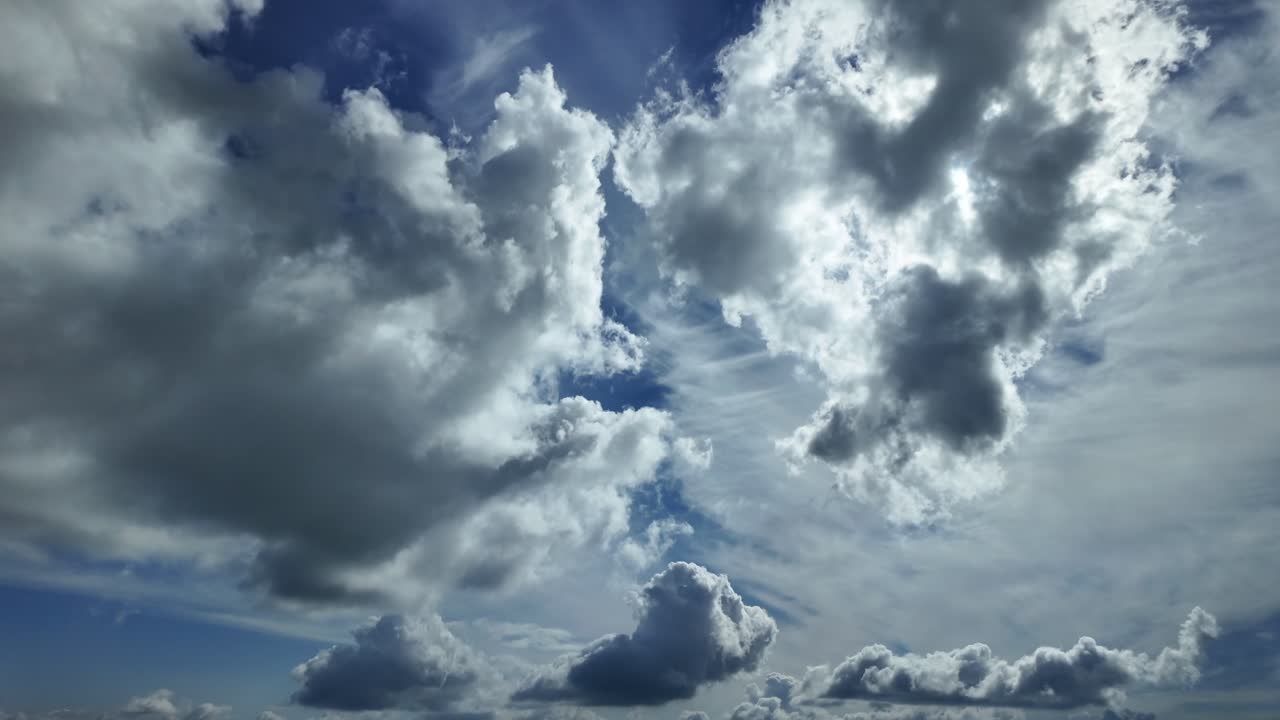 An aerial view through the pilot’s eyes from cockpit of an aerial dynamic claudscape, low angle shot, with a broken sky with scattered clopus and sun rays pirecing the clouds.