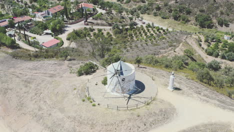 vuelo de drones sobre un antiguo molino de viento tradicional portugués en una montaña, recorrido redondo