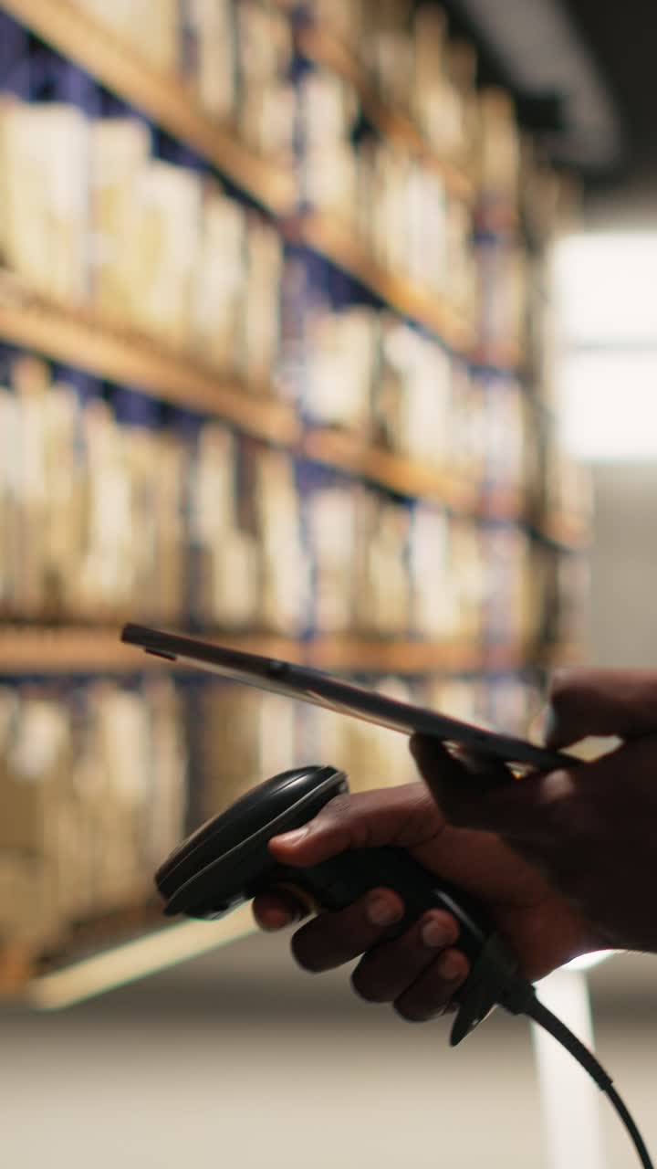 Vertical Video African american man using scanner to register barcodes tags in inventory