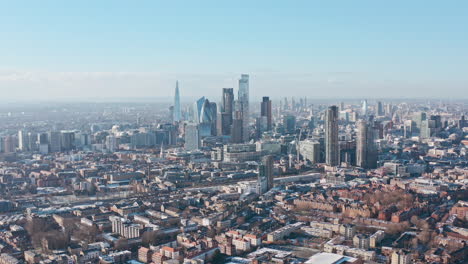 tight cinematic rotating aerial drone shot of city of london skyscrapers clear day after snow