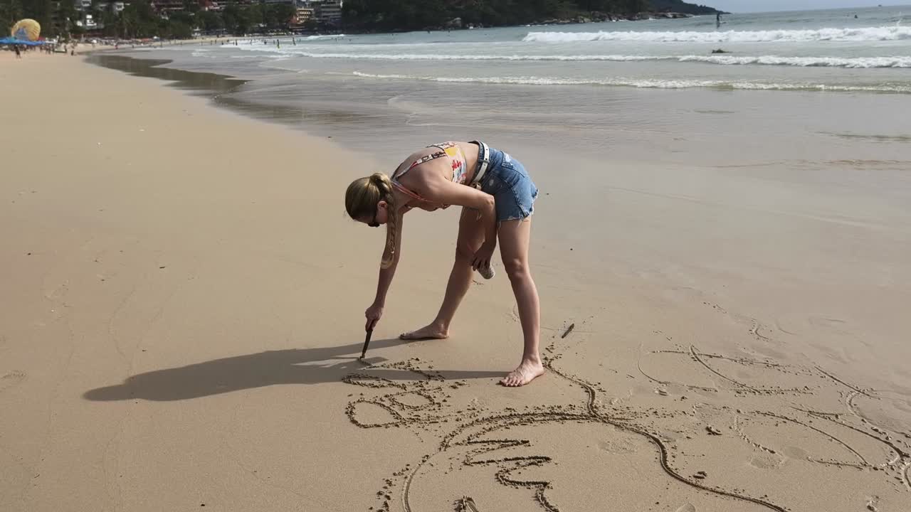 mujer dibujando en la arena en una playa tropical