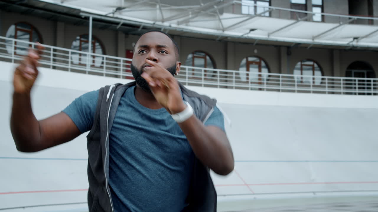 Sportsman performing hip hop dance on track