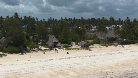 Drohne-Zoomt-Luxusbungalows-Auf-Der-Exotischen-Insel-Sansibar-Entlang-Der-Türkisblauen-Ozeanküste-Heraus