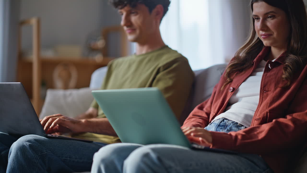 Freelancers couple working laptops at domestic interior closeup. Online family
