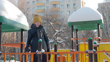 Fröhlicher-Und-Aktiver-Junge-Auf-Dem-Spielplatz-Im-Winter