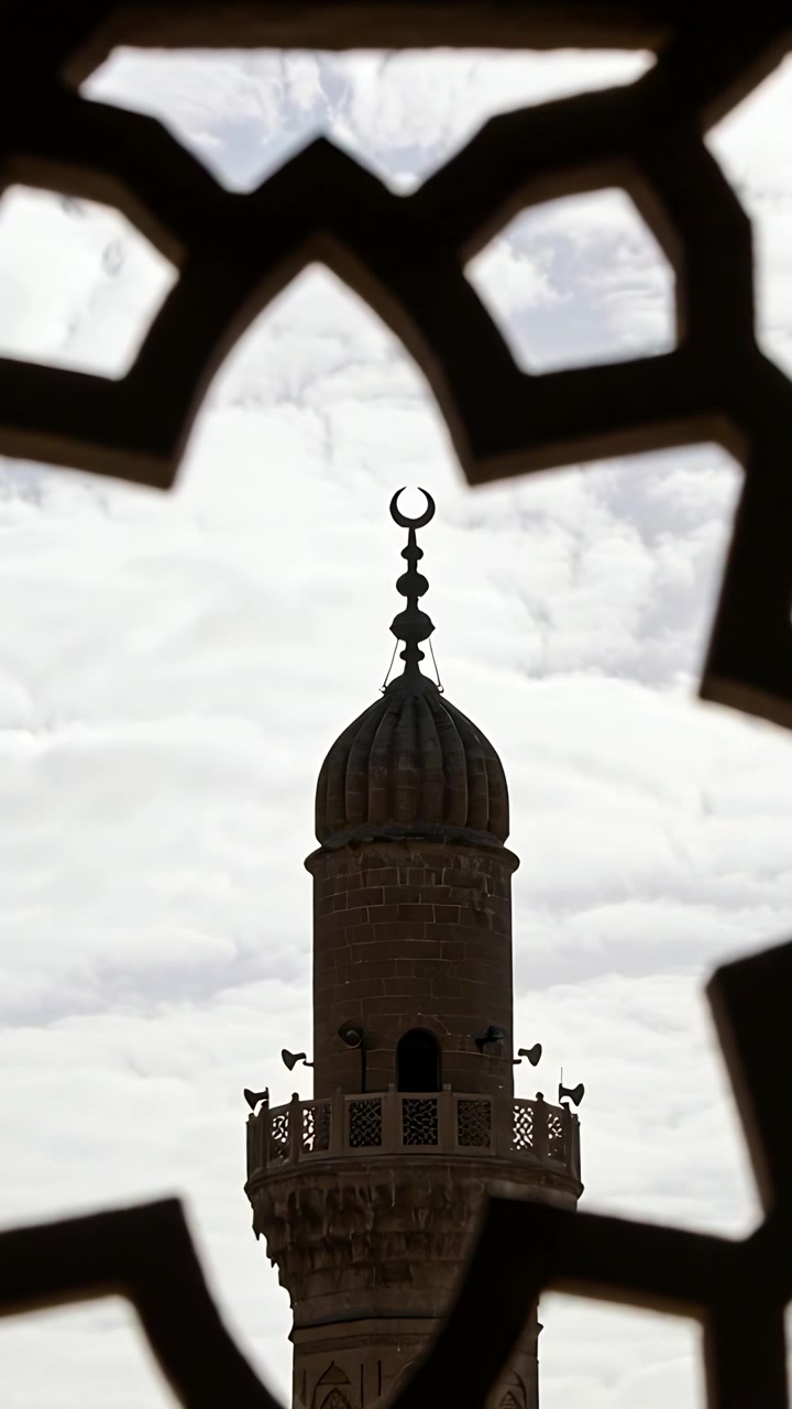 Video verticale: Telecamera che si sposta inquadrando la torre di un minareto da una finestra di una moschea, rivelando una cupola a costoloni.