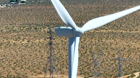 aerial parallax shot around a wind turbine, in the sunny mojave desert of usa