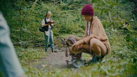 friends spending leisure time in forest during vacation