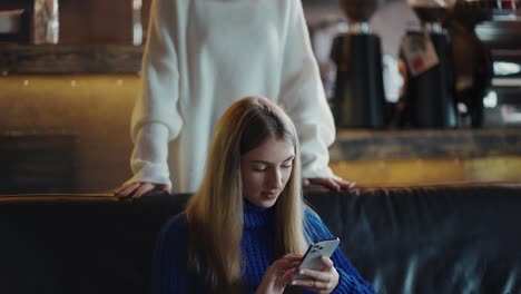 Amigas-Reunidas-En-El-Café,-Una-Amiga-Sorprendente-Desde-Atrás-Y-Un-Abrazo