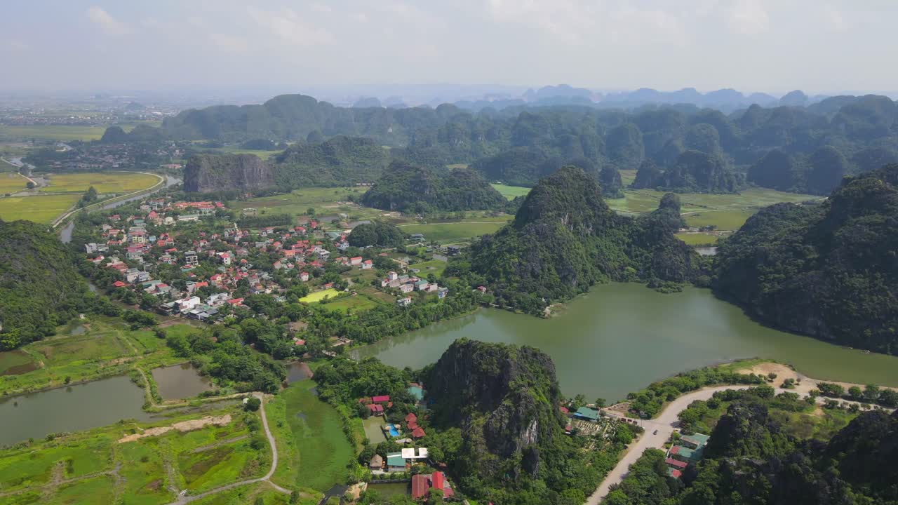 Stunning Aerial View of a Picturesque Village Nestled Among Karst Mountains and a Serene Lake in Vietnam