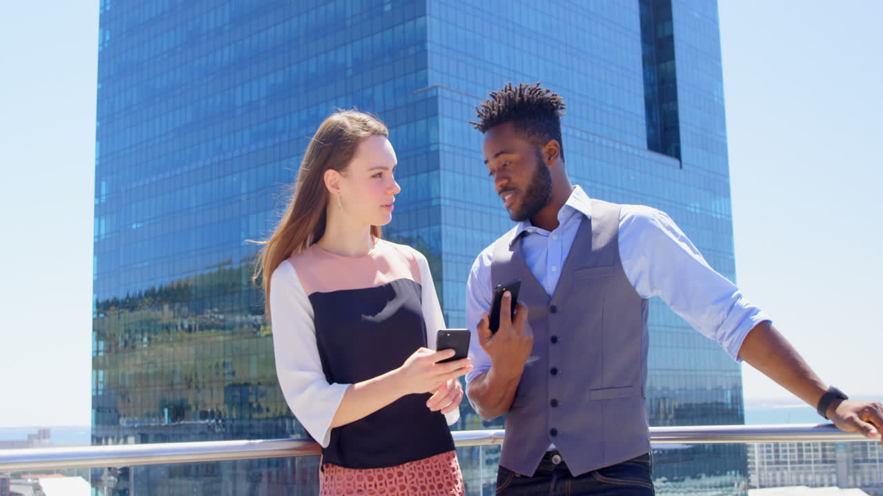 Front view of young mixed-race business team planning and standing in balcony of modern office 4k