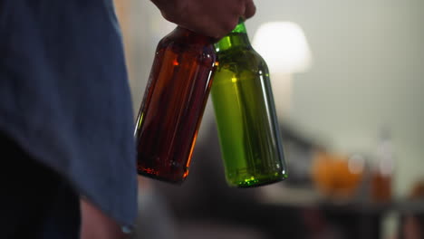 Black-sports-fan-carries-bottles-of-beer-to-table-with-chips