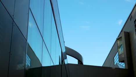 glass building with reflective surface and clear blue sky