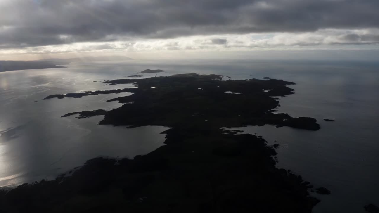 AERIAL - Epic silhouette of the Isle of Gigha at sunrise, Kintyre, Scotland, wide