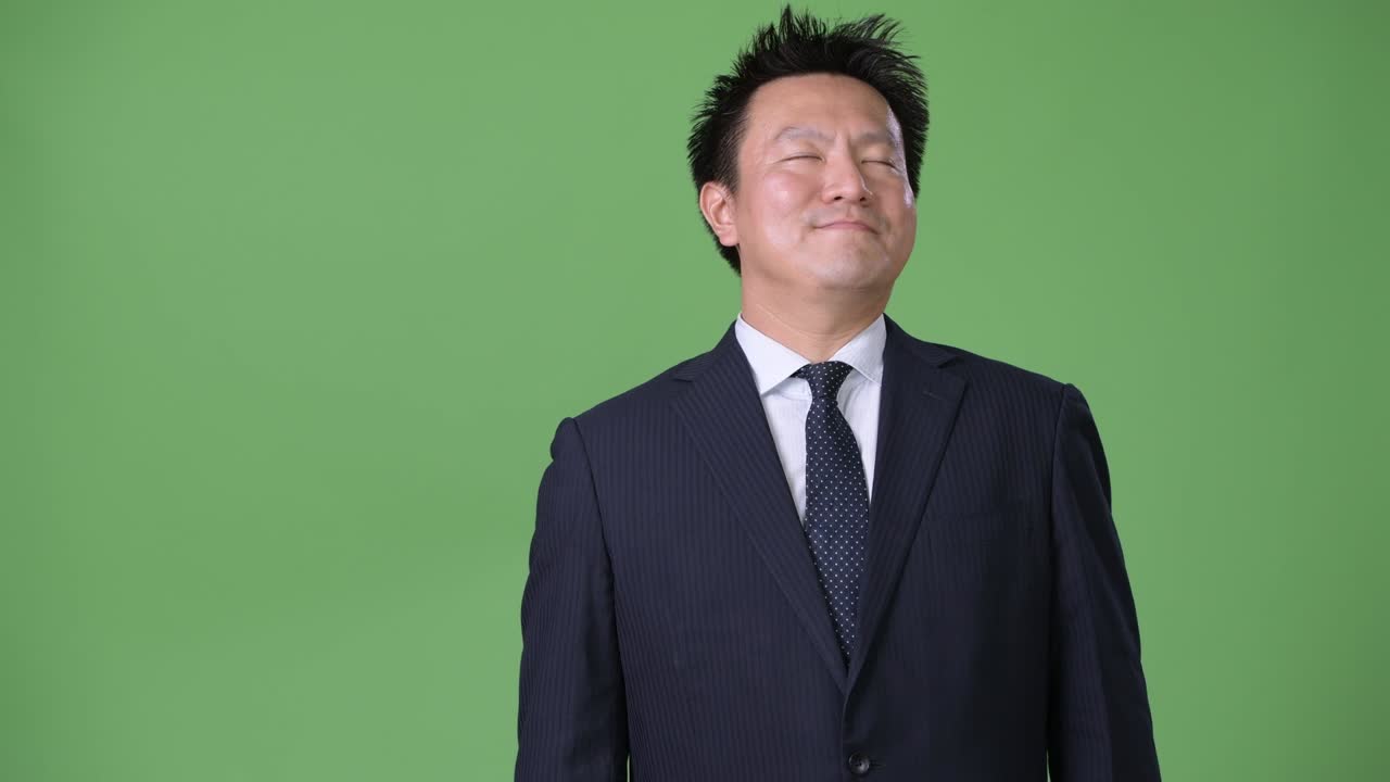 녹색 배경에 성숙한 일본 사업가
