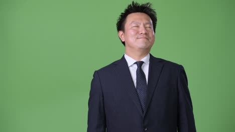 mature japanese businessman against green background