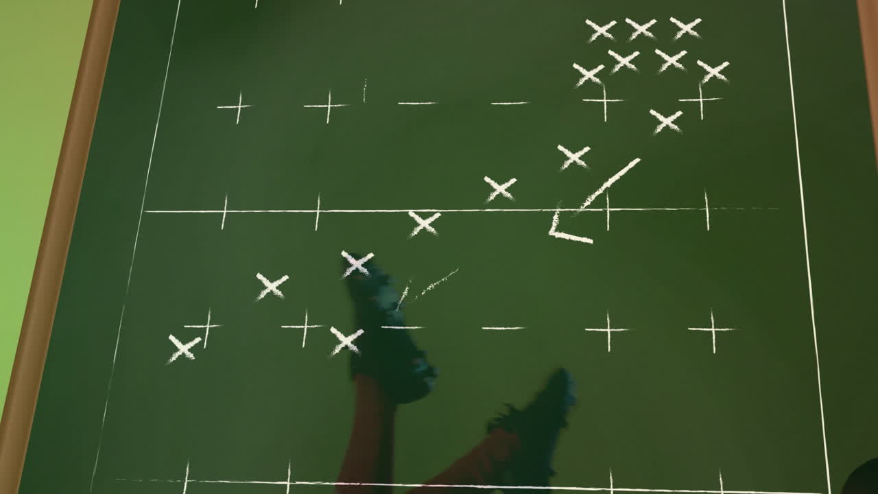 On green field, player studying sports strategy diagram for animation purposes
